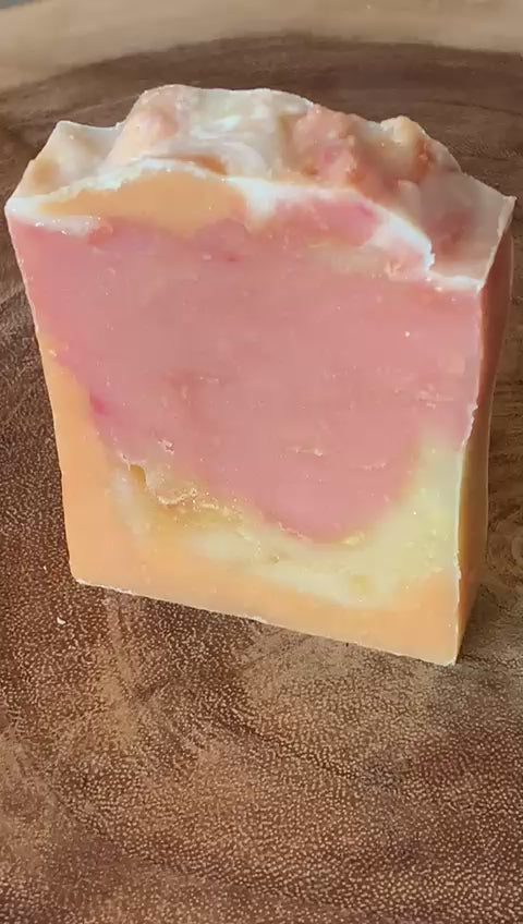 A bar of soap with pink and orange tones swirled through it.